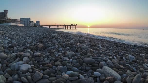 Panorama de la puesta del sol sobre el mar. Playa de piedra orilla con olas marinas . — Vídeos de Stock