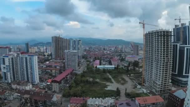 Desde el día hasta la noche Espacio de la ciudad con el sitio de construcción, rascacielos, tráfico y montañas. Timelapse. Batumi, Georgia — Vídeos de Stock