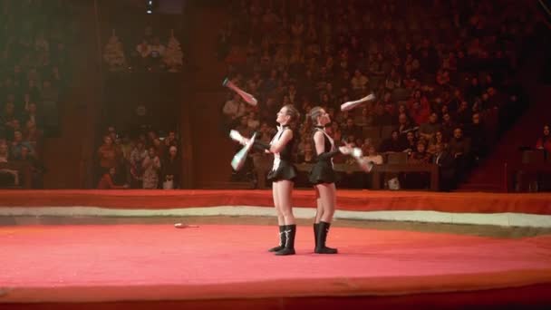 Het duo van tweeling meisjes jongleren met clubs voert trucs uit op het Circus podium — Stockvideo