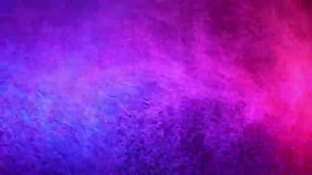 Pulvérisation d'eau rouge et bleue mélangée sur un fond noir. Mouvement lent 