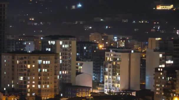 Multistorejské budovy s měnícím se oknem osvětlení v noci ve městě. Včasná — Stock video