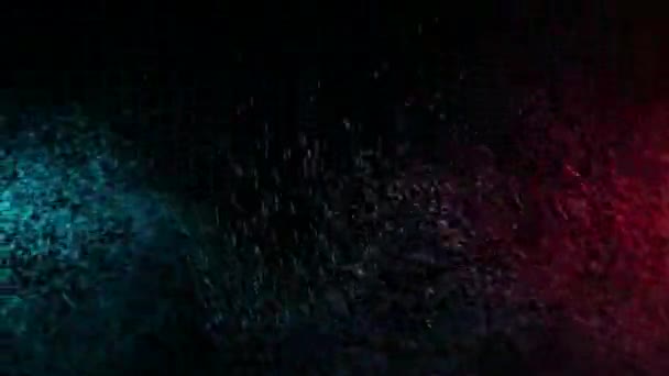 Pulvérisation d'eau verte et rouge mélangée sur un fond noir. Mouvement lent 
