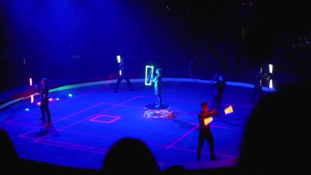 Circo. Show de néon com efeitos de iluminação na arena de circo. Espectadores assistem ao show — Vídeo de Stock