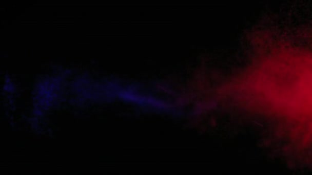 Pulvérisation d'eau rouge et bleue mélangée sur un fond noir. Mouvement lent 