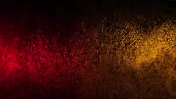 Piros és sárga vízpermet keverve egy fekete háttér. Lassú mozgás — Stock videók