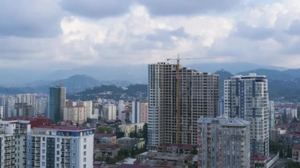 Construção civil. Timelapse. Guindaste de torre em um canteiro de obras levanta uma carga no prédio de arranha-céus . — Vídeo de Stock