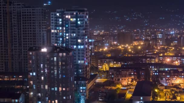 Edificios de varios pisos con iluminación cambiante de ventanas por la noche en la ciudad. Cronograma — Vídeo de stock