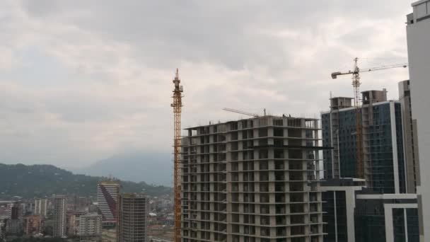 Construcción de edificios. Tower Crane en un sitio de construcción levanta una carga en un edificio de gran altura. Cronograma — Vídeo de stock