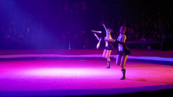 O Duo de meninas gêmeas malabarismo com clubes executa truques no palco do circo — Vídeo de Stock