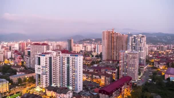 Día a noche Timelapse del espacio de la ciudad con rascacielos y ventanas cambiantes de luz. Batumi. — Vídeos de Stock