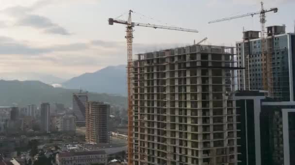 Construção civil. Timelapse. Guindaste de torre em um canteiro de obras levanta uma carga no prédio de arranha-céus . — Vídeo de Stock