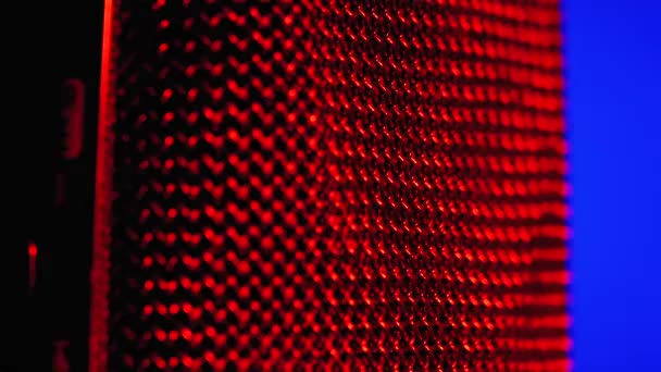 Kondensatormikrofon rotiert mit blauer und roter Hintergrundbeleuchtung. professionelle Audio-Recorder Nahaufnahme — Stockvideo