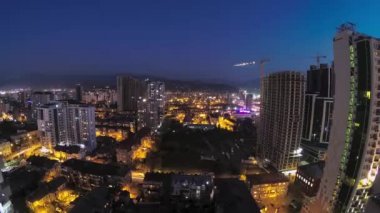 Building Construction from Day to Night. Timelapse. Tower Crane with Lighting in City Space