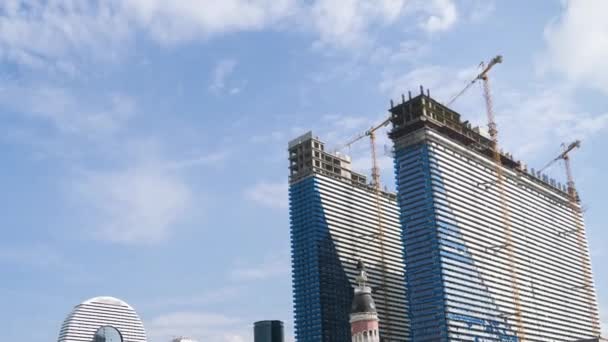 Výstavba moderních mrakodrapů pomocí Tower Cranes. Načasování. Pohybující se mraky na modré obloze — Stock video