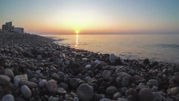 Panorama des Sonnenuntergangs über dem Meer. Steinstrand mit Meereswellen. — Stockvideo