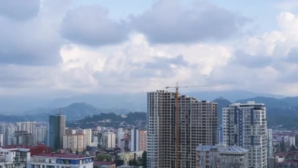 Building Construction. Timelapse. Tower Crane on a Construction Site Lifts a Load at High-rise Building. — Stock Video