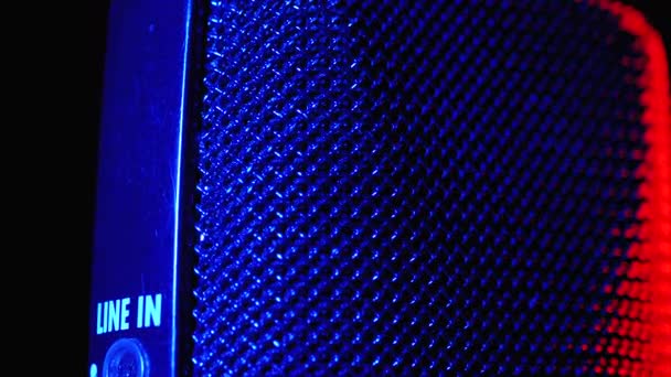 Micrófono de condensador gira con luz de fondo azul y rojo. Grabadora de audio profesional Primer plano — Vídeos de Stock
