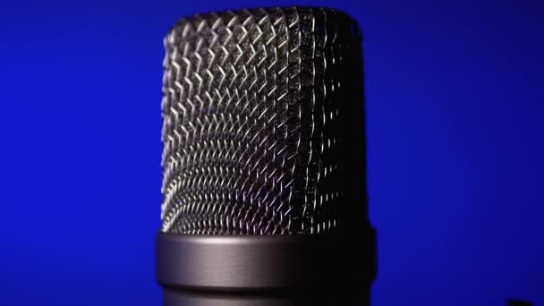 El micrófono de condensador Studio gira sobre fondo azul . — Vídeos de Stock