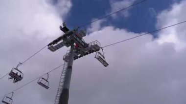 Ski Lift with Skiers on a Background of Blue Sky and Clouds. Ski Resort.