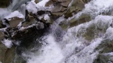 Waterfall Prut in the Winter. Rapid Flow of Water from a Mountain Creek and Stone Rapids with Snow
