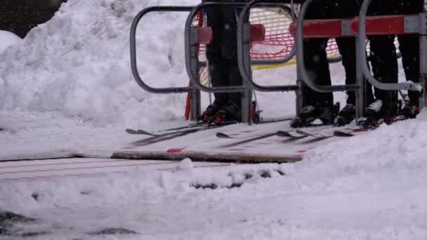 Los esquiadores pasan las puertas de un torniquete del telesilla. La entrada de una silla elevadora de esquí con esquiadores. Moción lenta — Vídeos de Stock