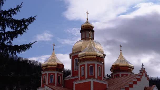 Iglesia ucraniana con cúpulas doradas contra el cielo y nubes en las montañas Cárpatas — Vídeo de stock