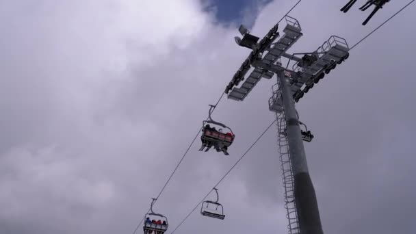 Elevador de esqui com esquiadores em um fundo de céu azul e nuvens. Estância de esqui . — Vídeo de Stock