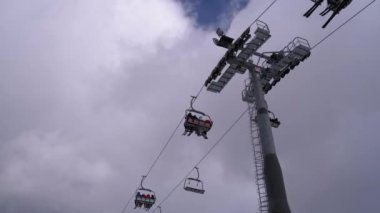 Ski Lift with Skiers on a Background of Blue Sky and Clouds. Ski Resort.