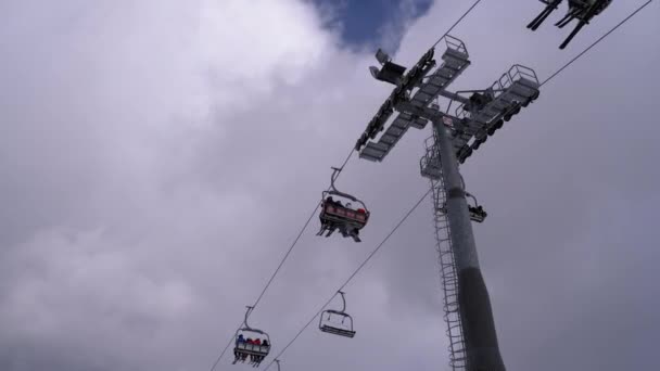 Elevador de esqui com esquiadores em um fundo de céu azul e nuvens. Estância de esqui . — Vídeo de Stock