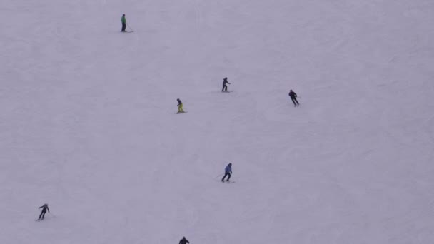 Esquiadores y snowboarders Cabalgan en una pista nevada en una estación de esquí en Sunny Day — Vídeo de stock
