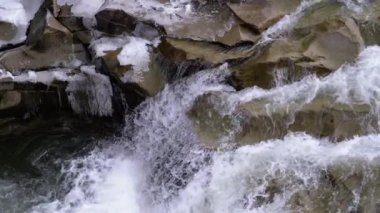 Mountain Creek and Stone Rapids with Snow. Rapid Flow of Water. Winter Waterfall. Slow Motion