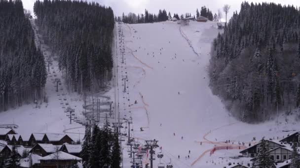 Ski Resort. Skiers Ride on a Snowy Slope in Cloudy Day. Bukovel, Carpathians. — стокове відео