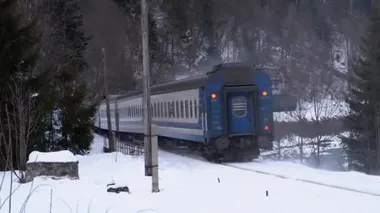 Old Train Rides on a Railway Crossing in the Countryside in Winter. Snow on the Ground.