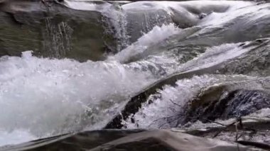 Mountain Creek and Stone Rapids with Snow. Rapid Flow of Water. Winter Waterfall. Slow Motion