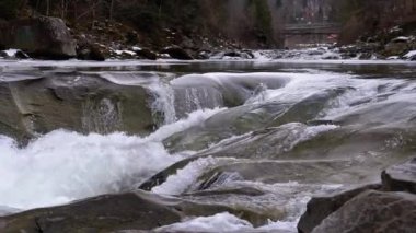 Mountain Creek and Stone Rapids with Snow. Rapid Flow of Water. Winter Waterfall. Slow Motion