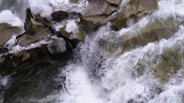 Mountain Creek and Stone Rapids with Snow. Rapid Flow of Water. Winter Waterfall. Slow Motion