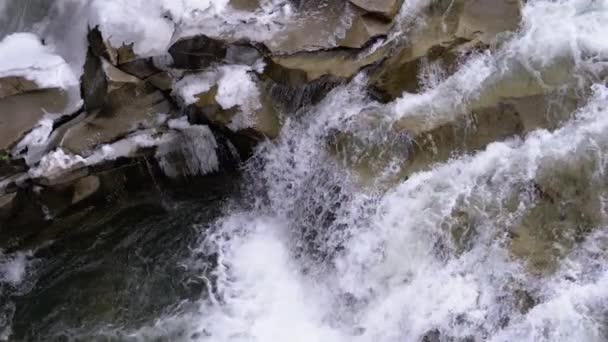 Горный ручей и каменные пороги со снегом. Быстрый поток воды. Зимний водопад. Slow Motion — стоковое видео