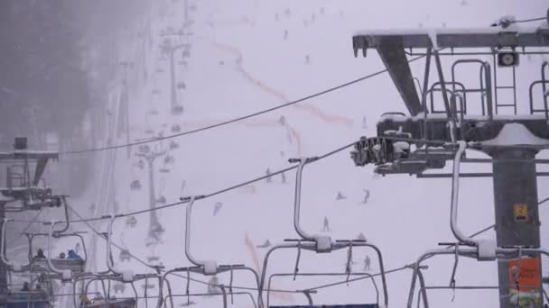 Ski Lift στο Χιονοδρομικό Κέντρο. σκιέρ Ανεβείτε σε μια καρέκλα σκι Ανελκυστήρας μέχρι Ski Slope με πτώση χιόνι — Αρχείο Βίντεο