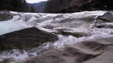Mountain Creek and Stone Rapids with Snow. Rapid Flow of Water. Winter Waterfall. Slow Motion