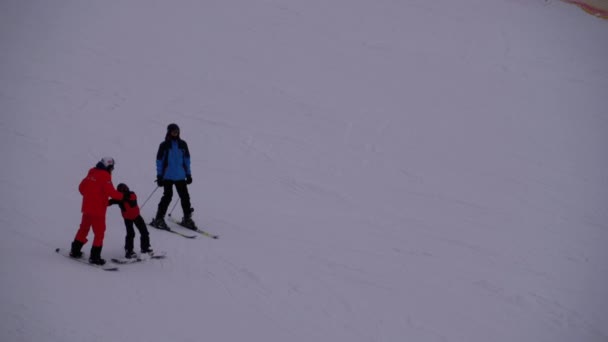 Les skieurs et les snowboarders montent sur une piste enneigée dans une station de ski — Video