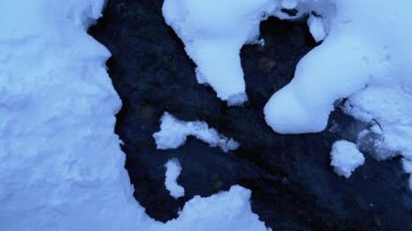 Mountain Stream in Winter Forest. Mountain River Flowing under Ice and Snow in Winter Landscape