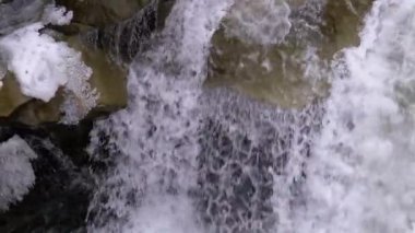 Mountain Creek and Stone Rapids with Snow. Rapid Flow of Water. Waterfall in the Winter. Slow Motion