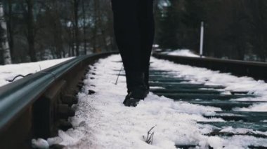 Legs of a Girl Walking along the Old Railway Tracks in Winter. Slow Motion