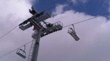 Ski Lift with Skiers on a Background of Blue Sky and Clouds. Ski Resort.