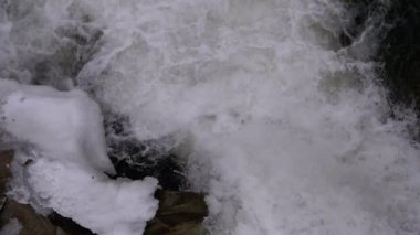 Mountain Creek and Stone Rapids with Snow. Rapid Flow of Water. Winter Waterfall. Slow Motion