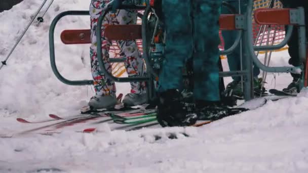 Os esquiadores passam por uma porta giratória do elevador de esqui. A entrada de uma cadeira de esqui levanta com esquiadores. Movimento lento — Vídeo de Stock