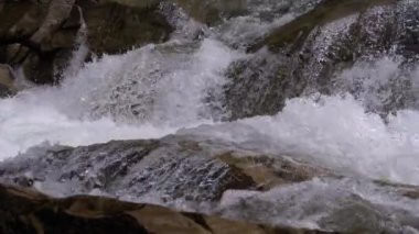 Mountain Creek and Stone Rapids with Snow. Rapid Flow of Water. Winter Waterfall. Slow Motion