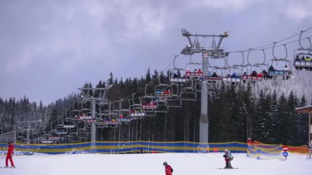 Elevador de esqui no Ski Resort. Esquiadores Suba em um elevador de cadeira de esqui até a encosta de esqui com neve caindo — Vídeo de Stock