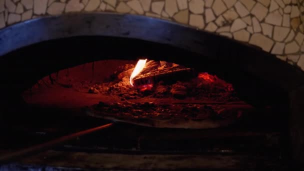 Cocinar pizza en un horno de arcilla a leña italiano en un restaurante — Vídeo de stock