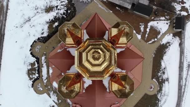 Bovenaanzicht op Oekraïense kerk met gouden koepels in Karpaten dorp in de winter — Stockvideo